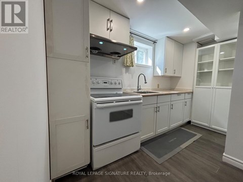 A kitchen with a stove top oven and a sink.