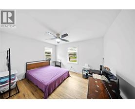 A bedroom with a bed, dresser, and window.