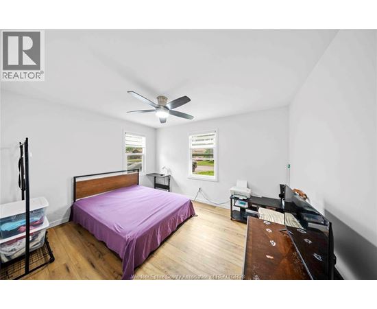 A bedroom with a bed, dresser, and window.