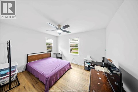 A bedroom with a bed, dresser, and window.