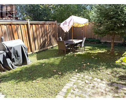 A patio with a table and chairs under an umbrella.