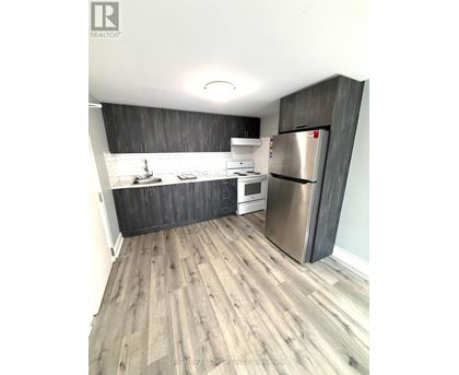 A kitchen with a refrigerator, stove, and sink.