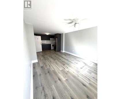 A room with a ceiling fan and wooden flooring.