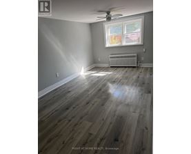 A room with a window and a radiator on the floor.