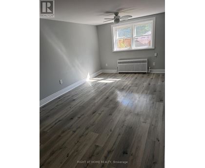 A room with a window and a radiator on the floor.