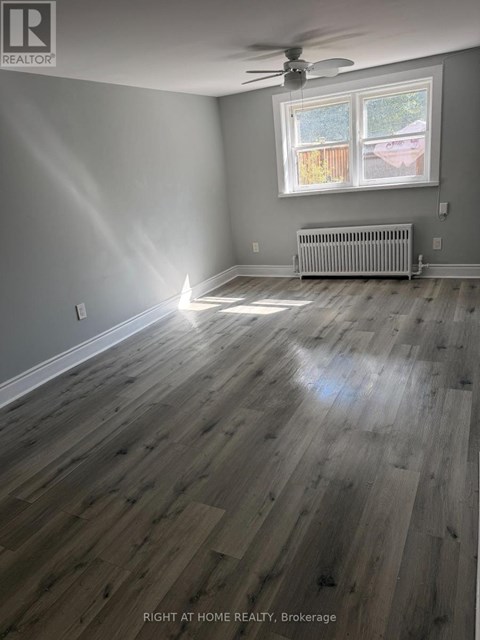 A room with a window and a radiator on the floor.