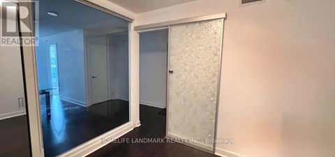 A room with a glass door and a white door with frosted glass.