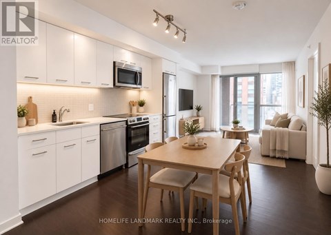 A modern kitchen with white cabinets and a wooden dining table.