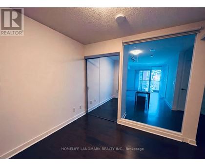 A room with a mirror showing a dining area.