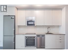 A modern kitchen with white cabinets and stainless steel appliances.