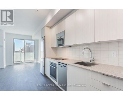 A modern kitchen with white cabinets and stainless steel appliances.