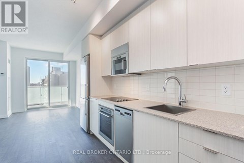 A modern kitchen with white cabinets and stainless steel appliances.