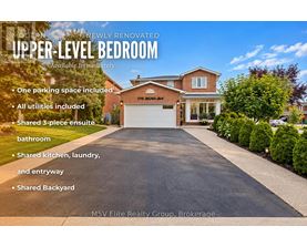 A house with a large driveway and a garage is for sale.
