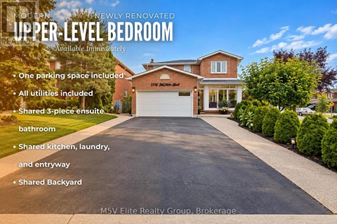A house with a large driveway and a garage is for sale.