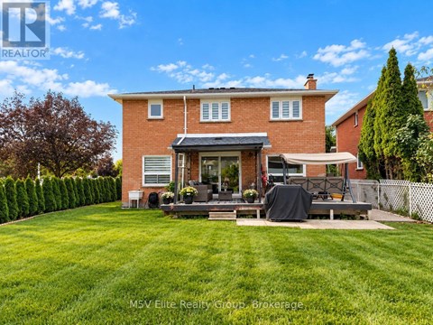 A house with a red brick exterior and a patio with a black tarp on it.