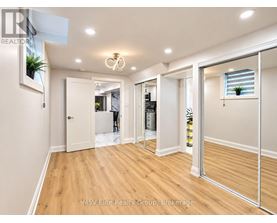 A spacious room with a wooden floor and white walls.
