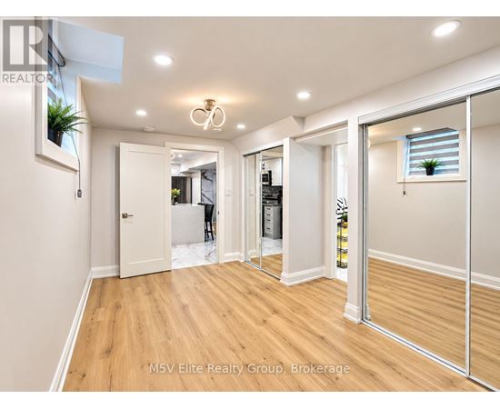A spacious room with a wooden floor and white walls.