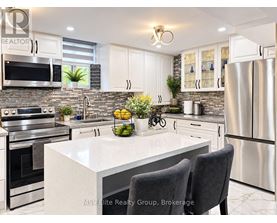 A modern kitchen with stainless steel appliances and a marble countertop.