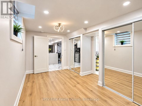 A spacious room with a wooden floor and white walls.