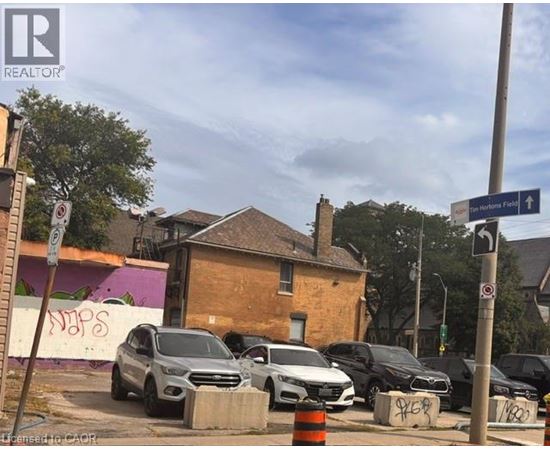 Cars parked on the side of the road near a brick building.