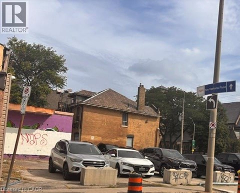 Cars parked on the side of the road near a brick building.