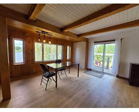 A dining room with a table and chairs.
