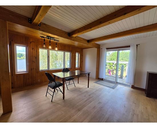 A dining room with a table and chairs.
