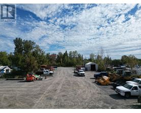 A parking lot with several vehicles and a construction site in the background.