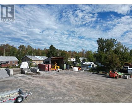 A construction site with a trailer and a building in the background.