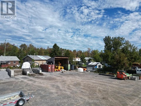A construction site with a trailer and a building in the background.