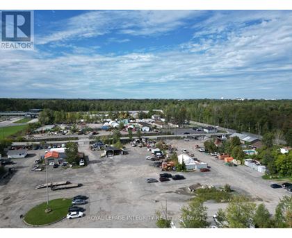 A bird's eye view of a parking lot with cars and buildings.