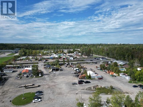 A bird's eye view of a parking lot with cars and buildings.
