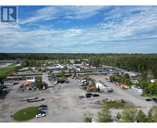 A bird's eye view of a parking lot with cars and buildings.
