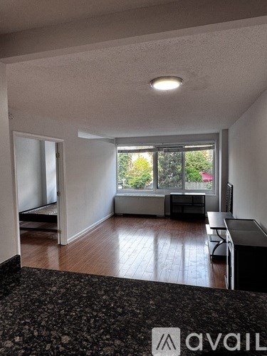 A living room with a couch, chair, and window.