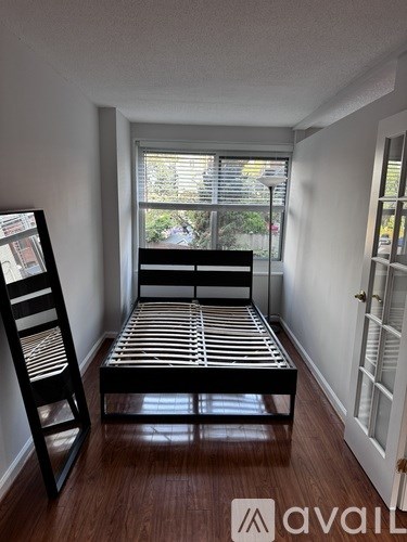 A bedroom with a bed and a chair.