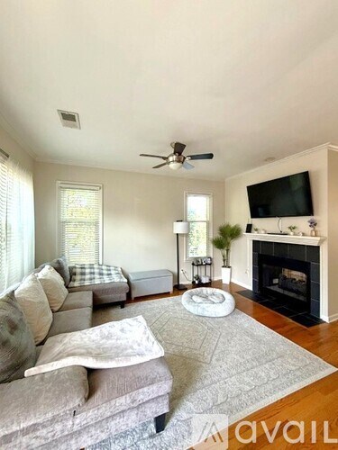 A living room with a grey couch and a fireplace.