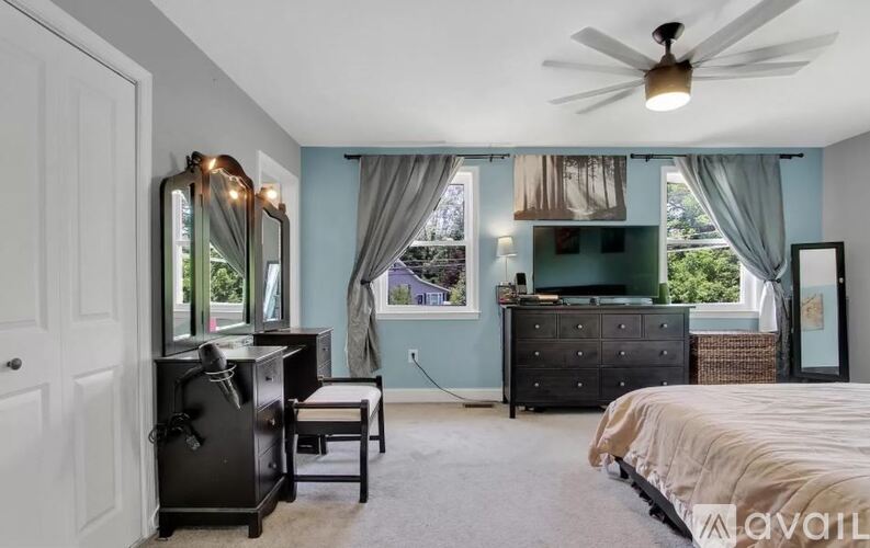 A bedroom with a bed, dresser, and mirror.
