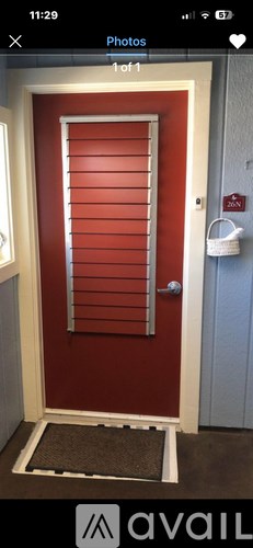 A red door with a white frame and a doormat in front.