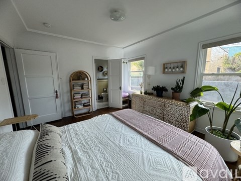 A bedroom with a large bed and a window with a view of the outside.