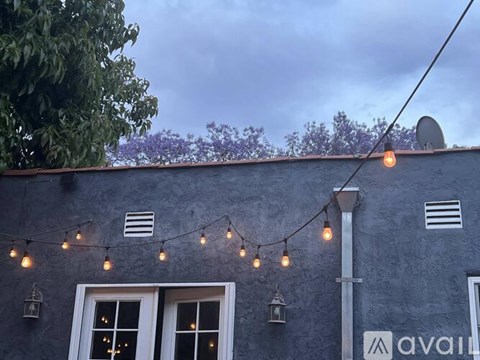 A building with a sign that says "AVAIL" and string lights hanging from the roof.