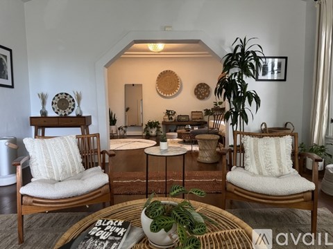 A living room with a woven coffee table and two chairs.
