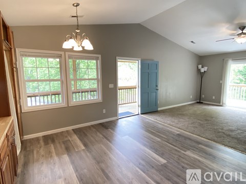 A spacious room with wooden flooring and a ceiling fan.