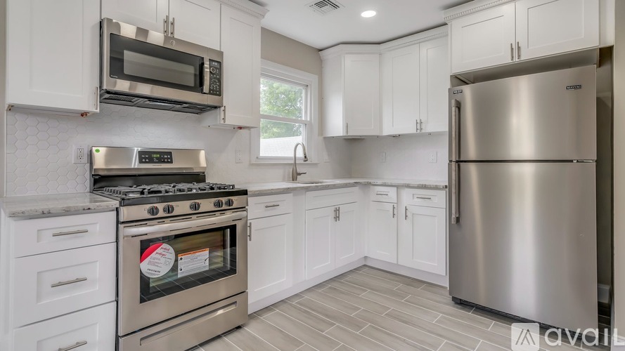 A modern kitchen with a stainless steel refrigerator, oven, and microwave.