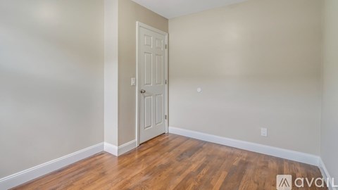A room with a wooden floor and a white door.