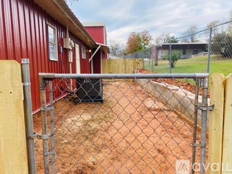A red building with a chain link fence in front of it.