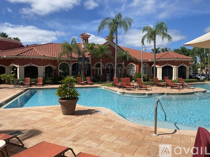 A pool area with a red tiled building in the background.