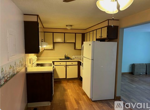 A kitchen with a white refrigerator and wooden floors.