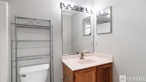 A bathroom with a white tub, sink, and mirror.