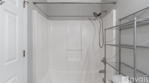 A white bathroom with a shower and a towel rack.