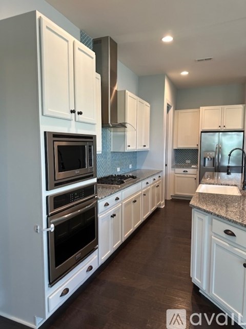 A kitchen with white cabinets and appliances.